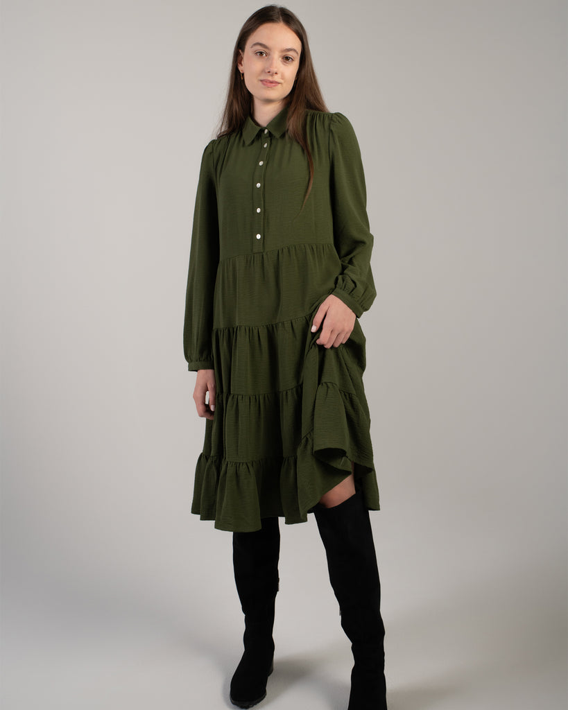 Young woman in a green knee-length, long sleeve dress