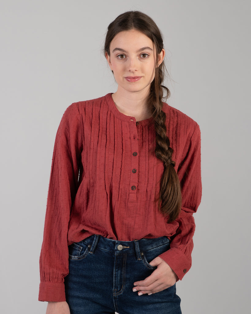 Woman in a red long sleeve blouse with dotted swiss detailing