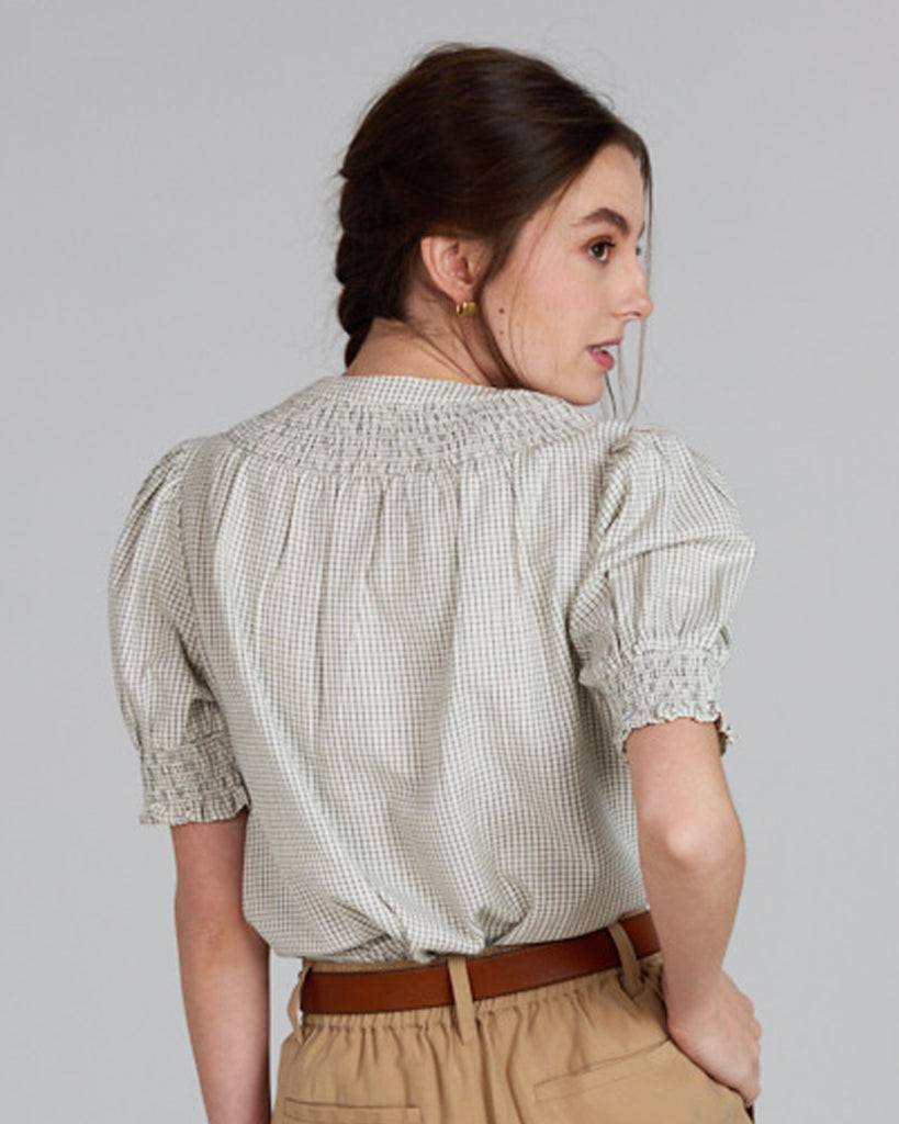 Model wearing a plaid beige short sleeve blouse.