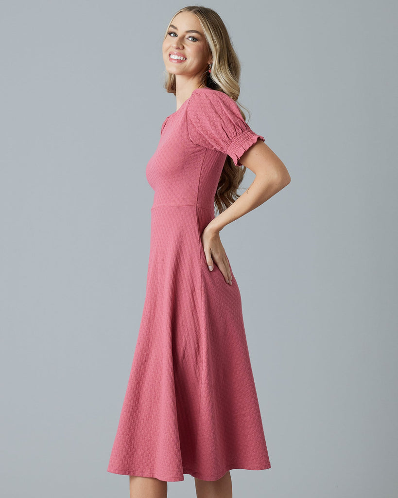 Woman in a pink short sleeve, midi-dress