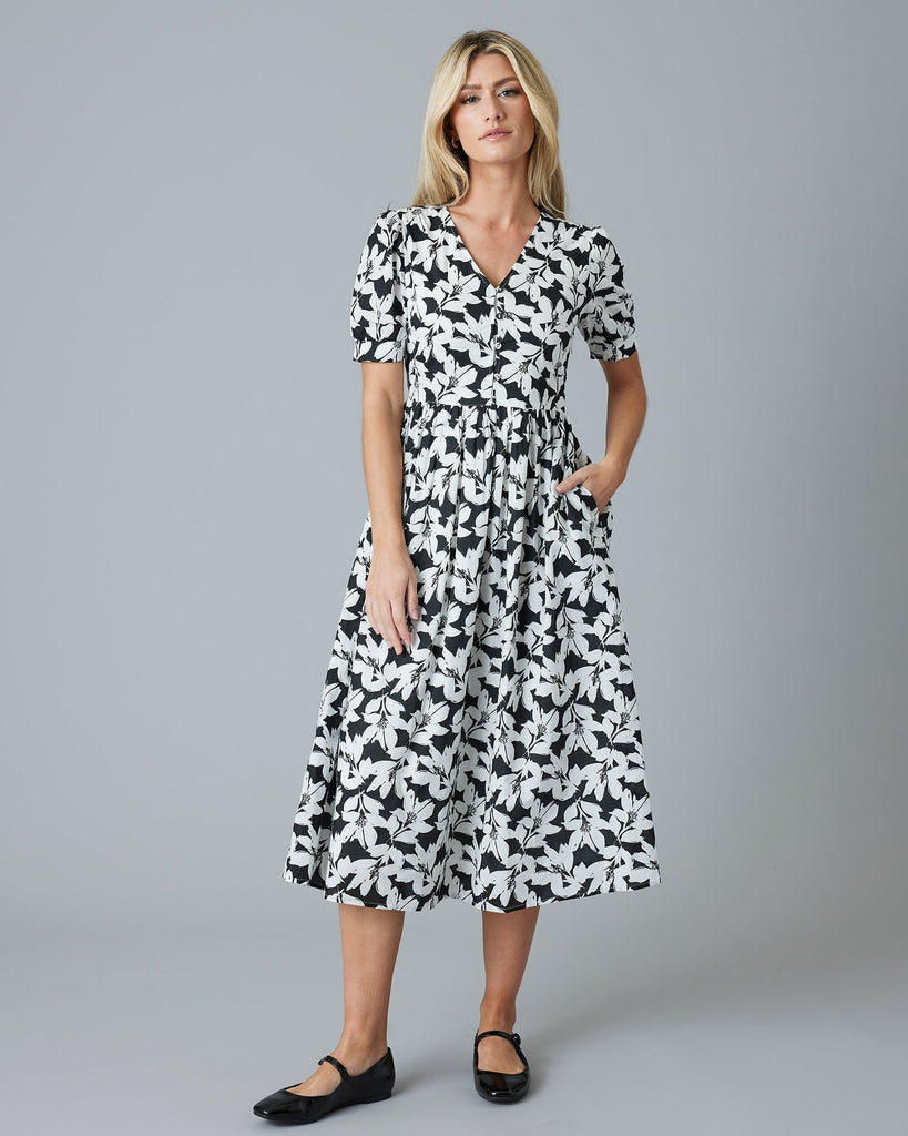 Woman in a black and white floral short sleeve midi-length dress