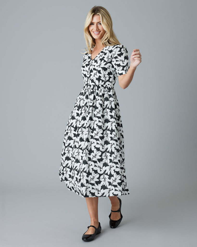 Woman in a black and white floral short sleeve midi-length dress