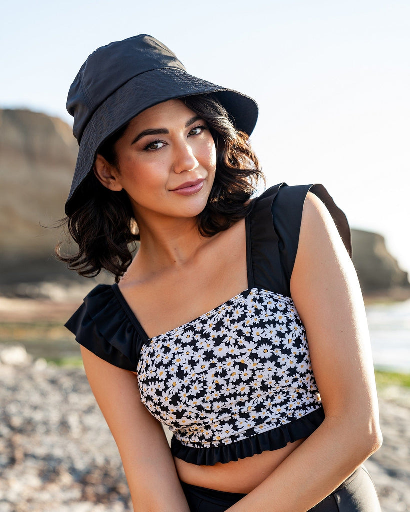 Woman in a two-piece swimsuit with a daisy print top.