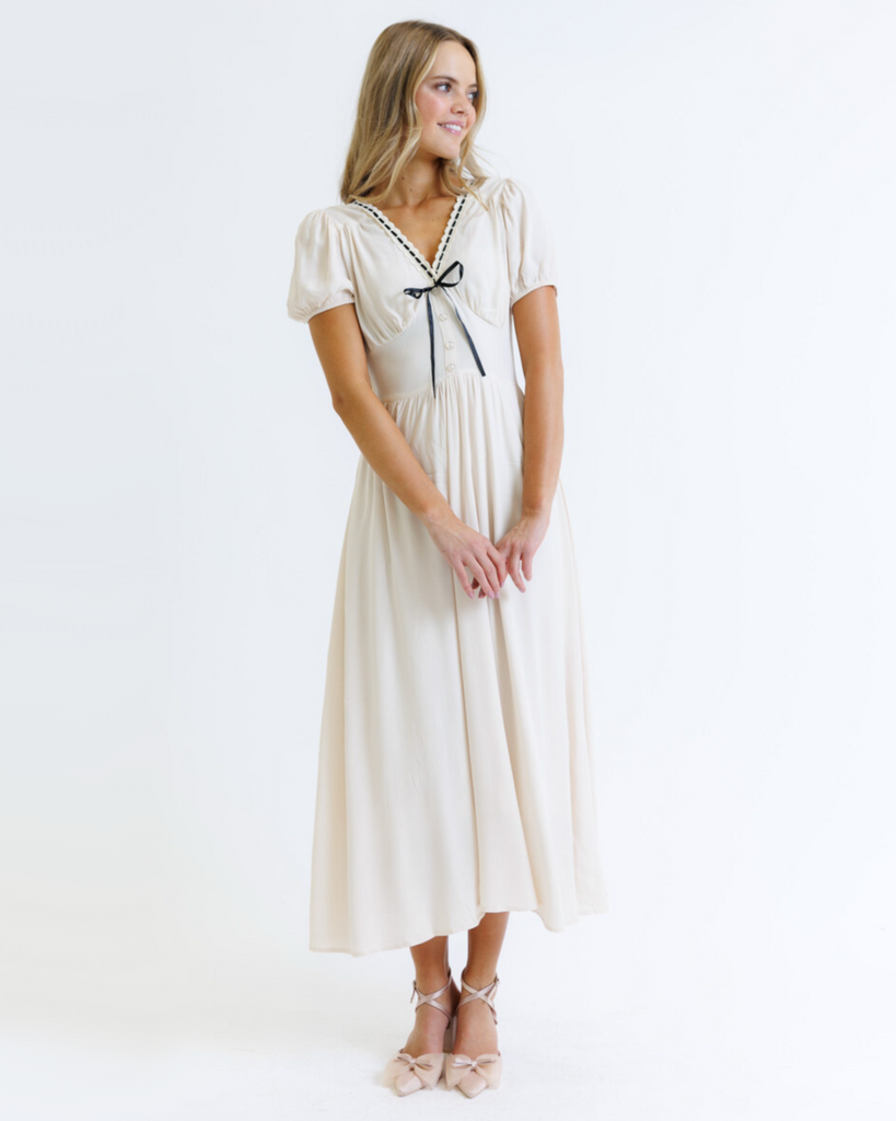 Woman wearing a white dress with a black ribbon on a white background