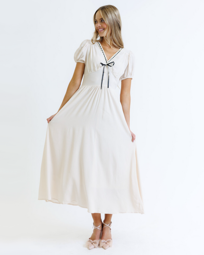 Woman wearing a white dress with black details on a white background