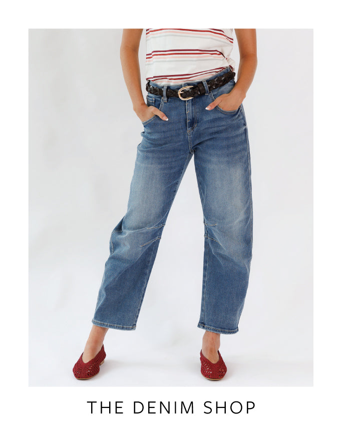 Person wearing blue jeans and a striped shirt with 'The Denim Shop' text.