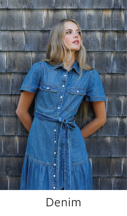 Woman wearing a denim dress standing against a wooden wall with 'Denim' text at the bottom.