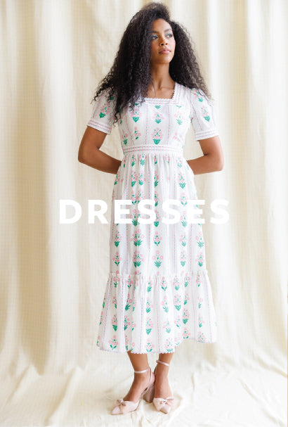 Image of woman wearing a white midi dress with DRESSES text