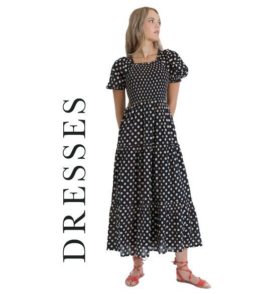 Woman wearing a black polka dot dress with 'DRESSES' text on a white background