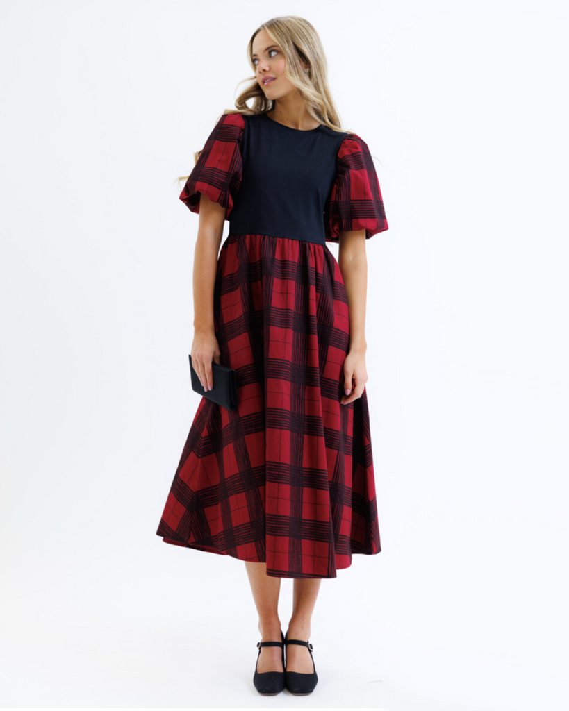 Woman wearing a red and black plaid dress on a white background