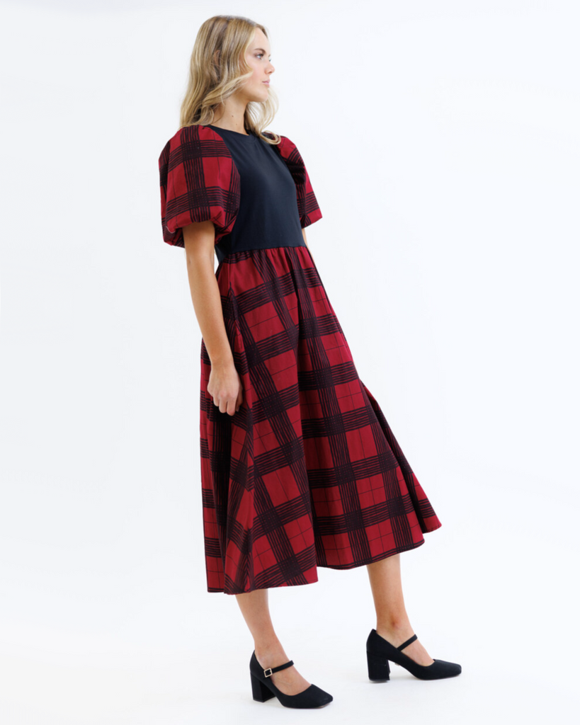 Woman wearing a red and black plaid dress on a white background