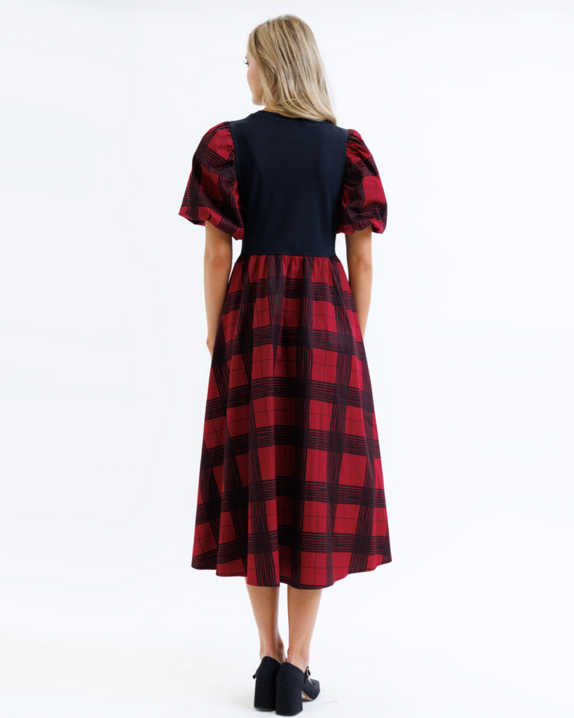 Woman wearing a red and black plaid dress on a white background