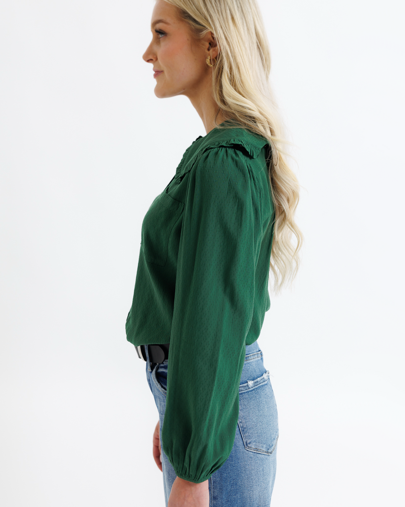 Woman wearing a green blouse and blue jeans on a white background