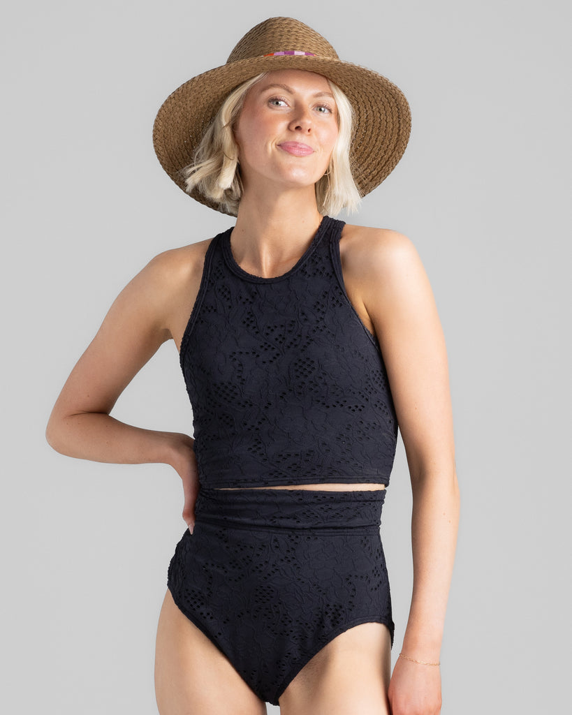 Model wearing a black racerback tankini with matching high-waisted swim bottoms.