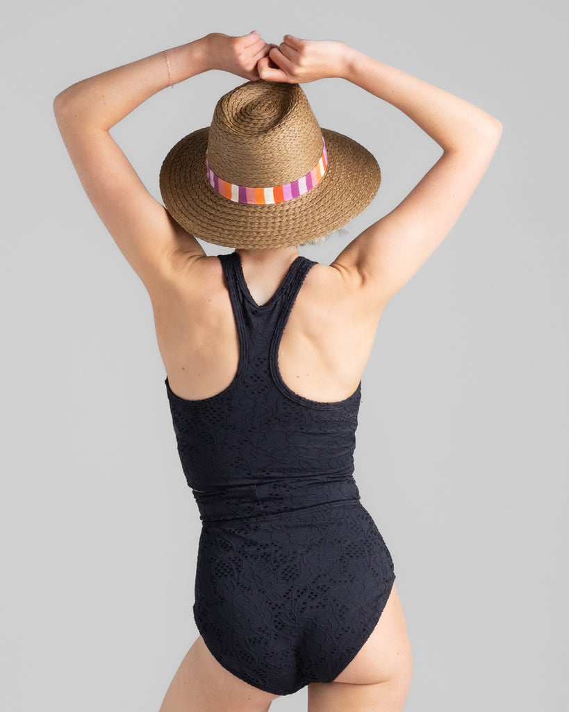 Model wearing a black racerback tankini with matching high-waisted swim bottoms.