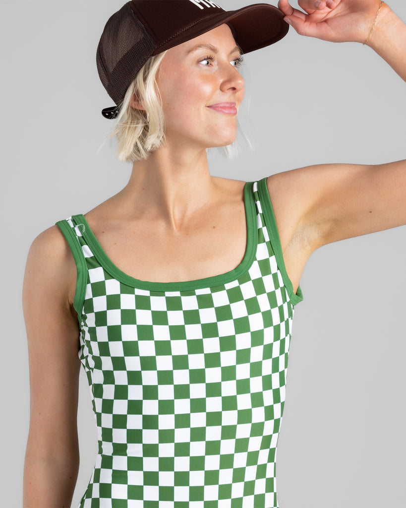 Model wearing a green and white checkered one-piece swimsuit. 