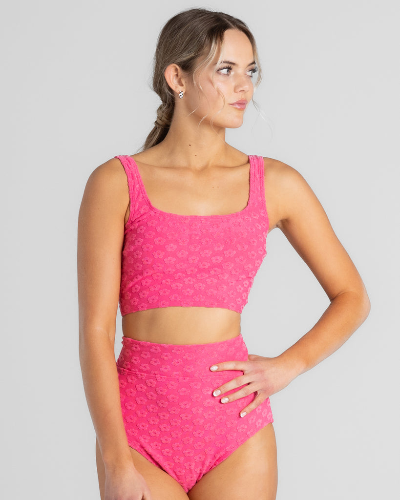 Model wearing a pink square neck cropkini with matching high waisted swim bottoms.