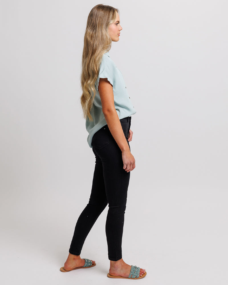 Woman in a high-waisted, black, denim pant