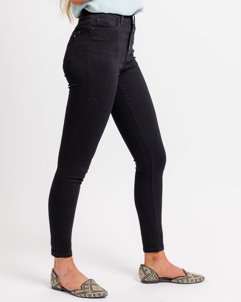 Woman in a high-waisted, black, denim pant