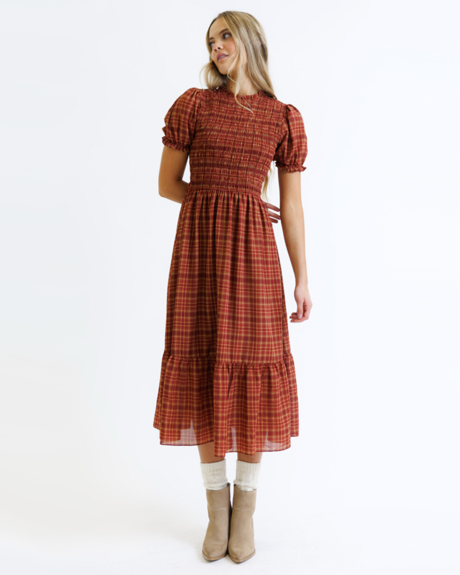 Woman wearing a red and orange plaid dress on a white background