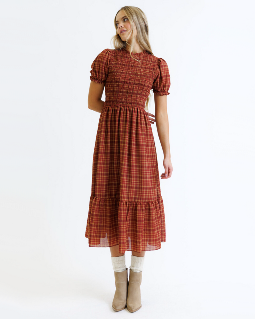 Woman wearing a red and orange plaid dress on a white background