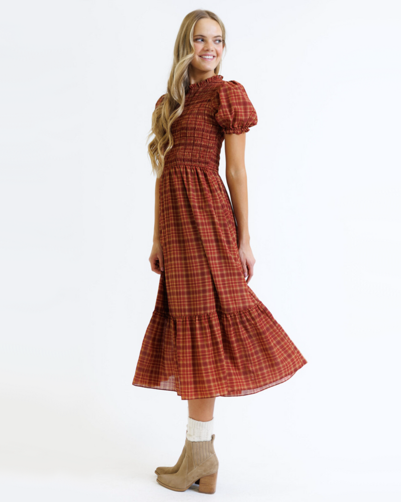 Woman wearing a red and orange plaid dress on a white background
