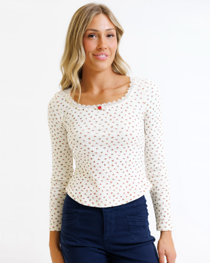 Woman wearing cream floral long sleeve with pointelle fabric on a white background