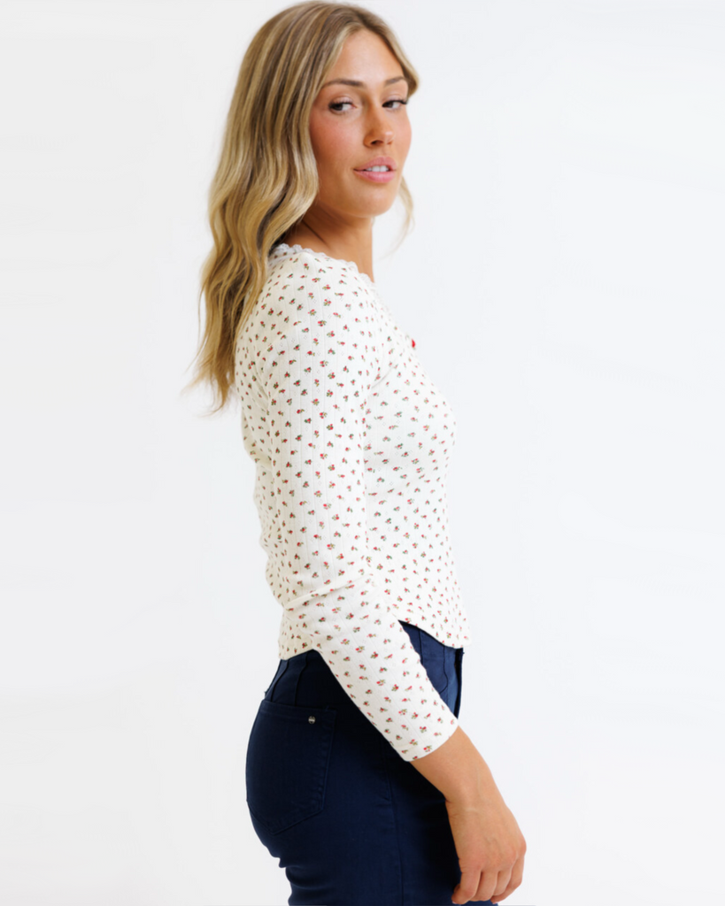 Woman wearing cream floral long sleeve with pointelle fabric on a white background