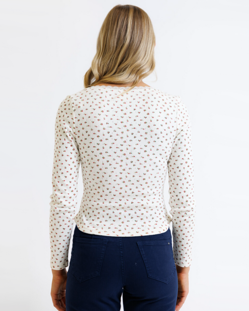 Woman wearing cream floral long sleeve with pointelle fabric on a white background