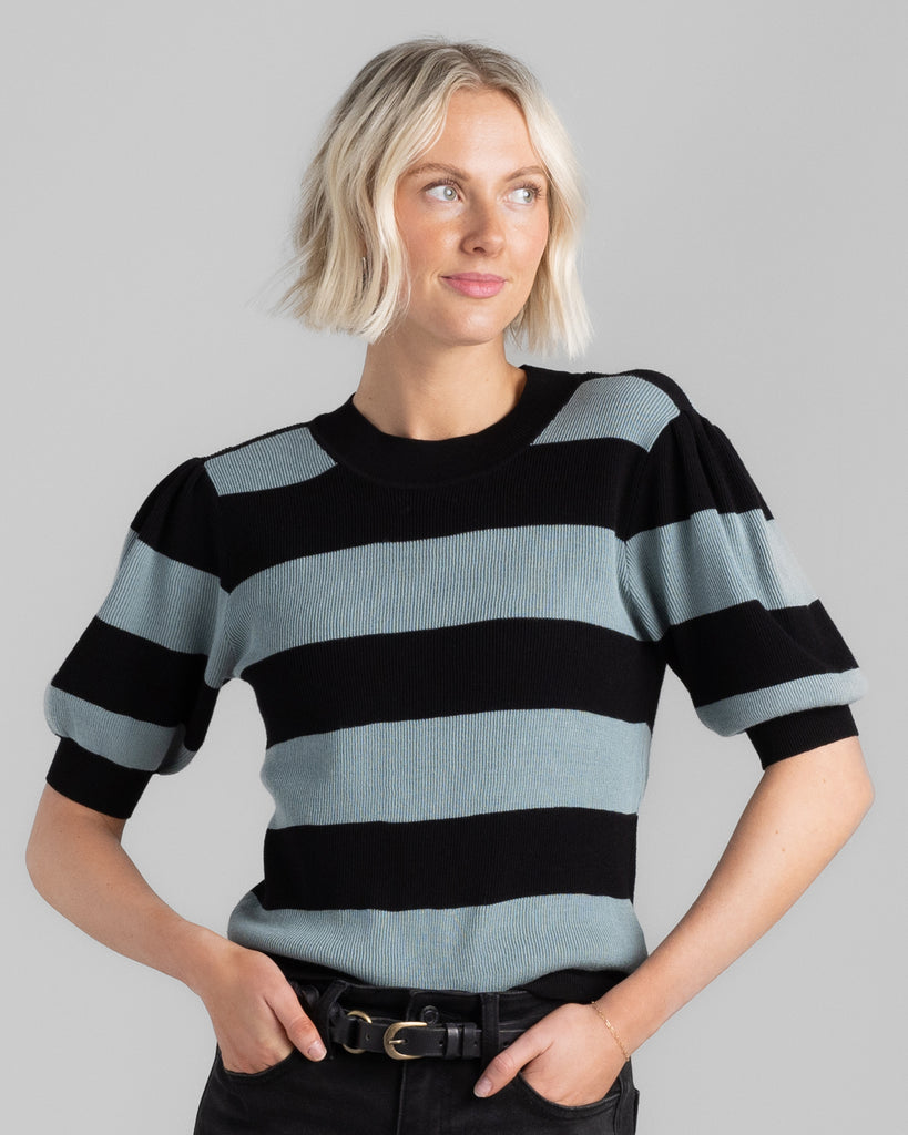 Model wearing a black and teal wide striped, short sleeve, crew neck sweater.