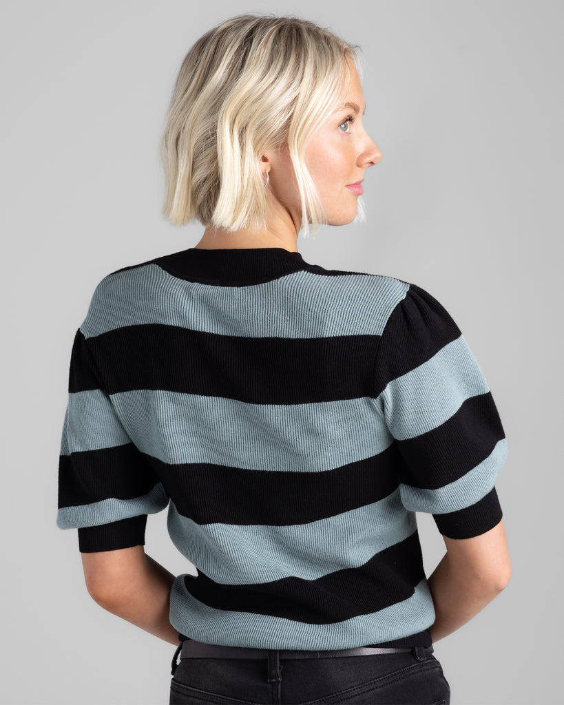 Model wearing a black and teal wide striped, short sleeve, crew neck sweater.