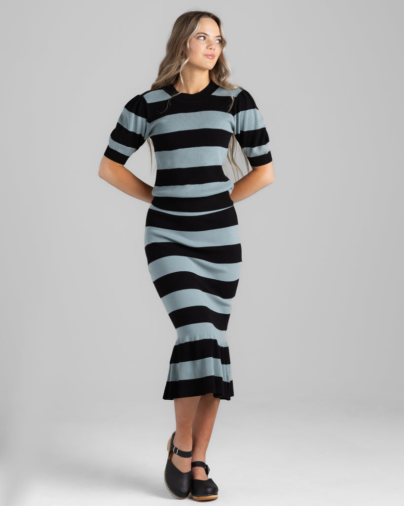 Model wearing a black and teal wide striped, short sleeve, crew neck sweater.