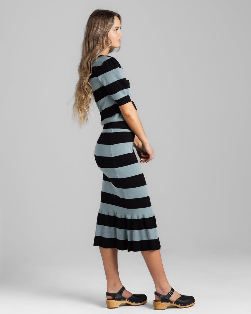 Model wearing a black and teal wide striped pencil knit midi skirt.