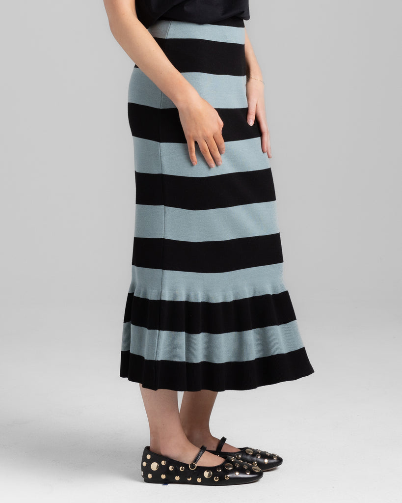 Model wearing a black and teal wide striped pencil knit midi skirt.