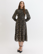 Woman wearing a black floral dress on a white background