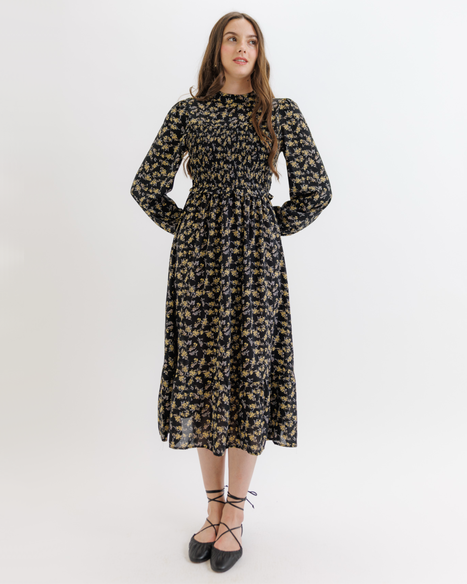 Woman wearing a black floral dress on a white background