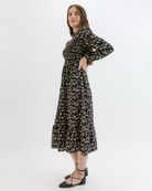 Woman wearing a black floral dress on a white background