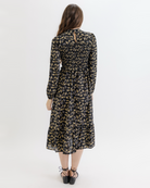 Woman wearing a black floral dress on a white background