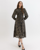 Woman wearing a black floral dress on a white background