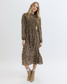 Woman wearing an olive green floral dress on a white background