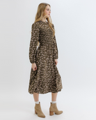 Woman wearing an olive green floral dress on a white background