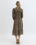 Woman wearing an olive green floral dress on a white background