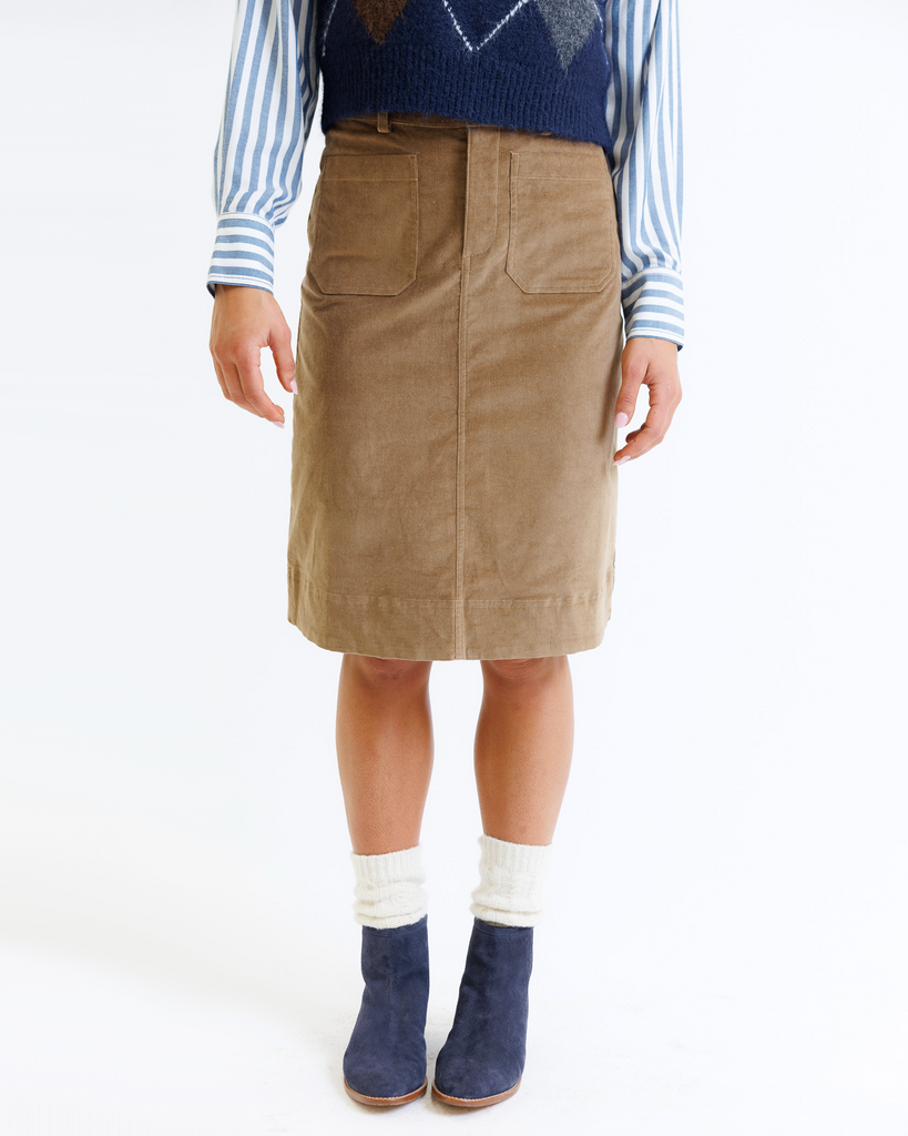 Woman wearing a brown corduroy skirt on a white background