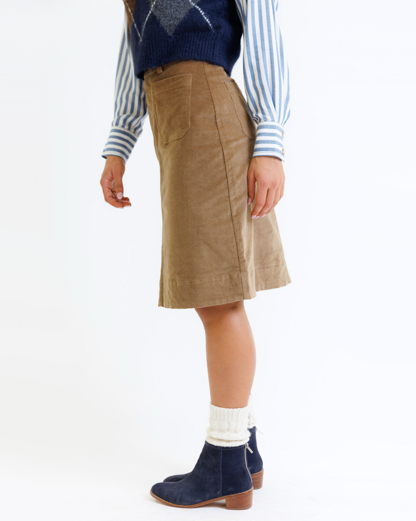 Woman wearing a brown corduroy skirt on a white background