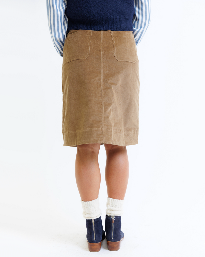 Woman wearing a brown corduroy skirt on a white background