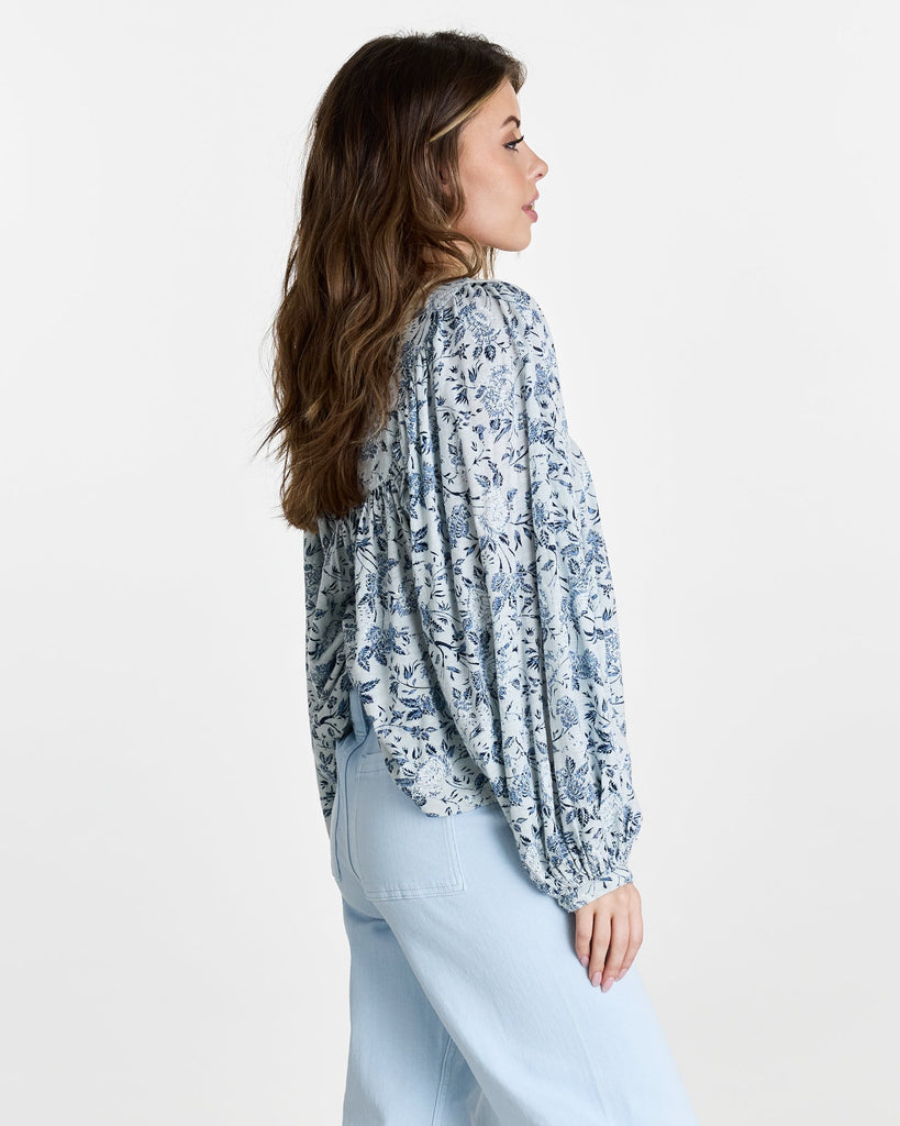 Woman in a blue floral print, long sleeve blouse