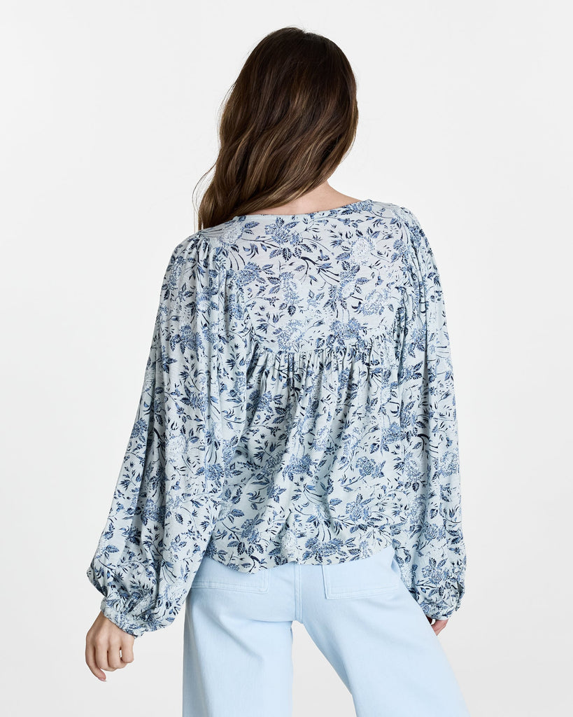 Woman in a blue floral print, long sleeve blouse