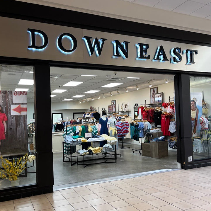 Storefront of a clothing store named 'DOWN EAST' with interior visible through glass doors.