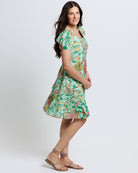 Model wearing a green with pink and yellow floral print short sleeve square neck knee length dress.