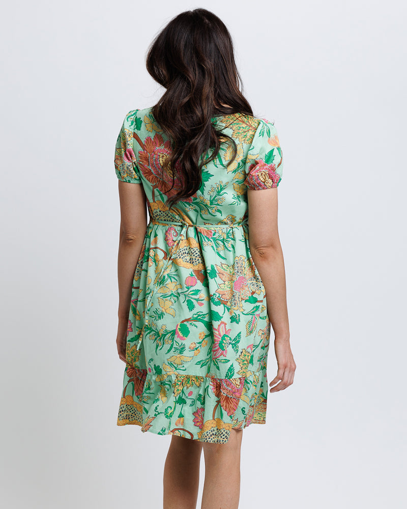 Model wearing a green with pink and yellow floral print short sleeve square neck knee length dress.